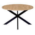 Table ronde en bois clair avec pied en métal noir.